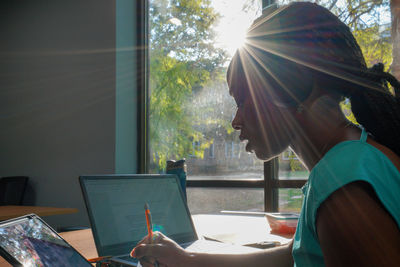 Side view of man using mobile phone in cafe