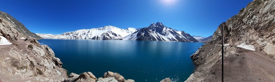 Panoramic view of snowcapped mountains against clear blue sky