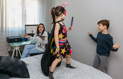 Children playing bothering their mother who is teleworking at home