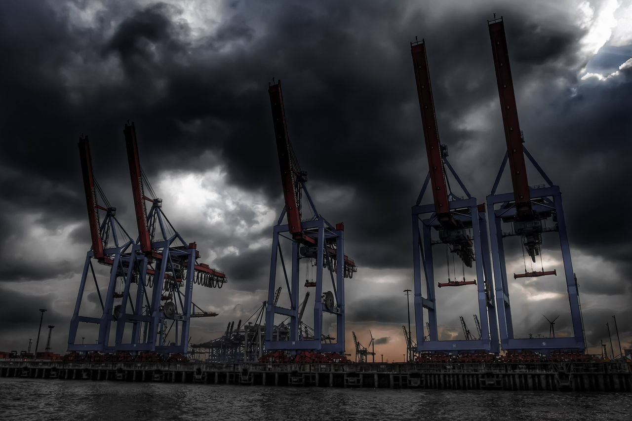 sky, cloud - sky, cloudy, built structure, architecture, water, cloud, crane - construction machinery, weather, industry, sea, overcast, waterfront, development, dusk, commercial dock, crane, harbor, building exterior, low angle view