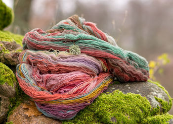 Stones overgrown with green moss, colored wool yarn skeins, handicraft concept, hand knitting