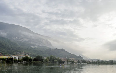 Scenic view of lake by mountains against sky