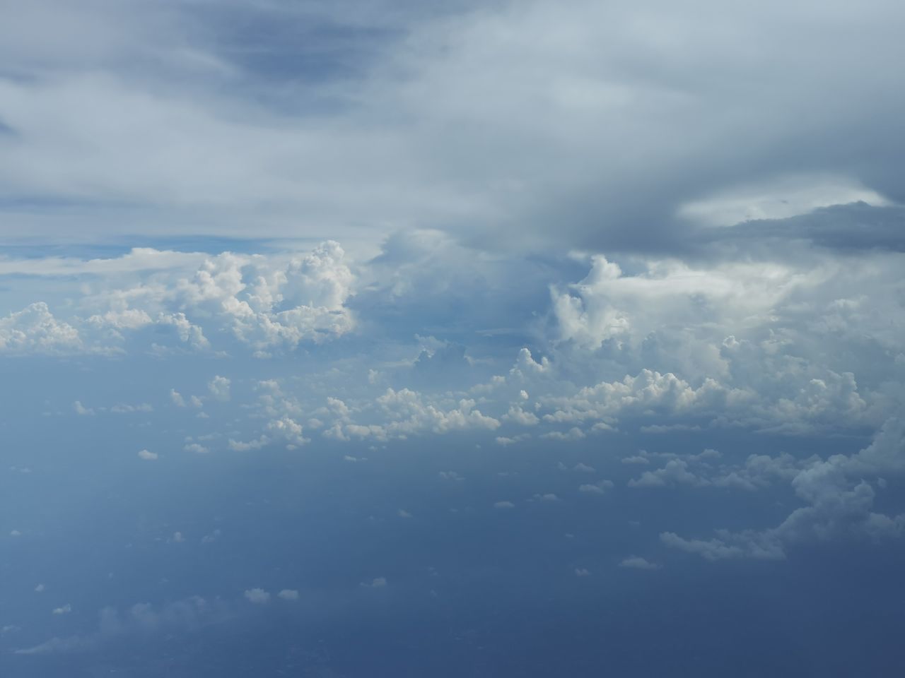sky, cloud, beauty in nature, nature, cloudscape, horizon, environment, scenics - nature, no people, aerial view, day, tranquility, outdoors, airplane, blue, sunlight, tranquil scene, white, overcast, idyllic, atmosphere, mountain, winter, fluffy, air vehicle, snow, backgrounds, flying, cold temperature, high up