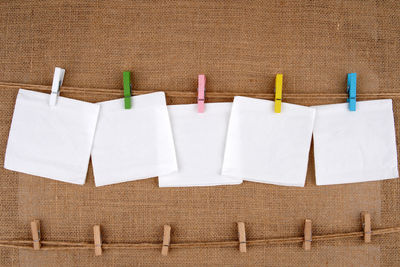 Close-up of clothespins hanging against white wall