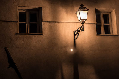 Low angle view of illuminated light mounted on wall