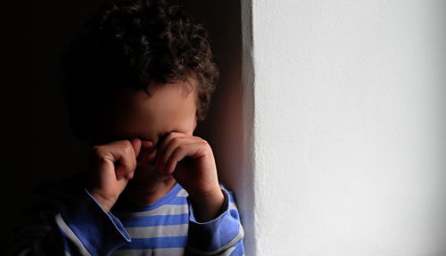 Portrait of boy standing against wall