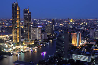 Illuminated buildings in city against sky at night