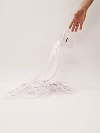Cropped image of hand throwing paper shredder and mug over white background