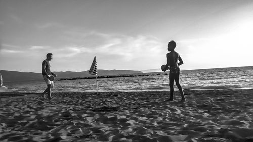 People on beach against sky