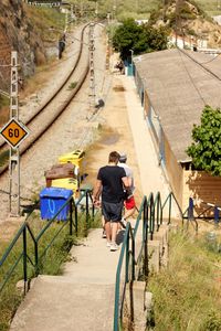 Rear view of men walking towards station platform
