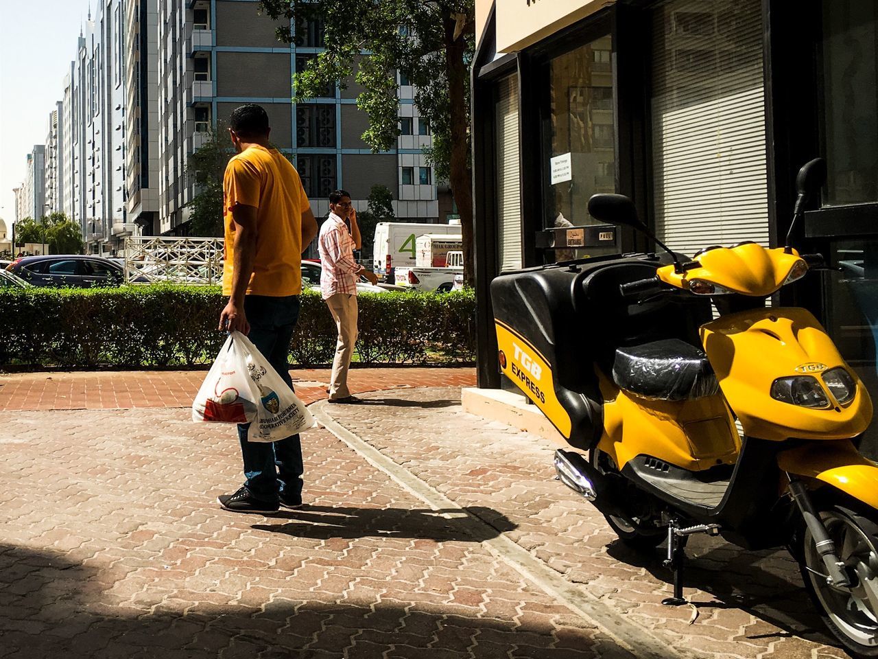 building exterior, architecture, built structure, street, full length, city, men, rear view, land vehicle, yellow, transportation, sunlight, outdoors, house, residential building, day, residential structure, mode of transport