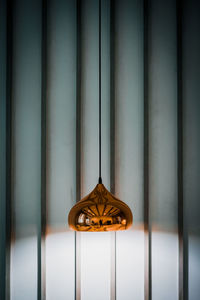 Close-up of illuminated lamp against wall at home