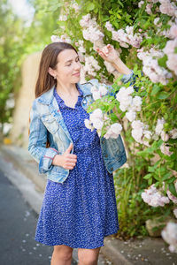 Lifestyle portrait of young stylish woman staying on the street in old town