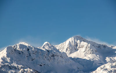 Scenic view of snowcapped mountains against clear blue sky