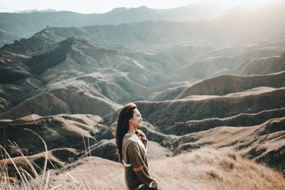 Side view of woman standing on mountain