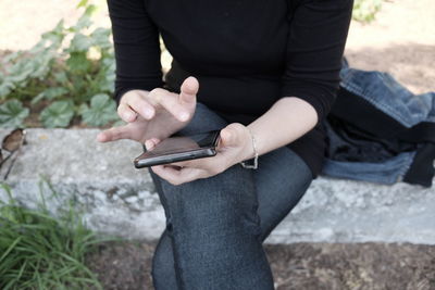 Midsection of woman using mobile phone