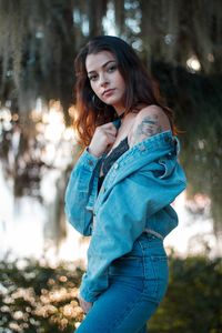 Portrait of beautiful young woman standing on land