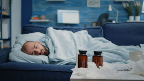 Sick man resting on sofa at home