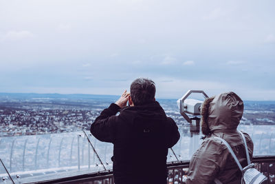 Rear view of man photographing cityscape