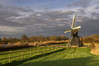 Windmill on field against sky