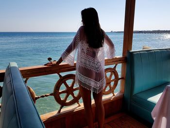 Rear view of woman looking at sea against sky