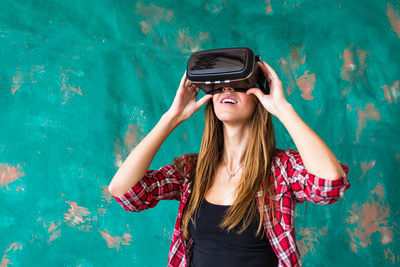 Woman standing outdoors wearing virtual reality headset