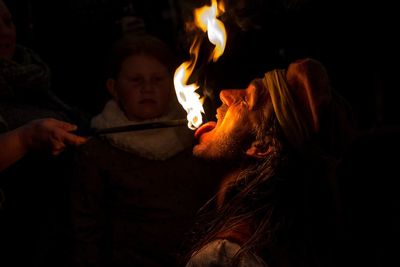 Close-up of fire eater at night