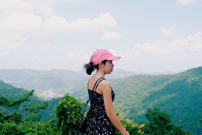 Woman standing on mountain against sky