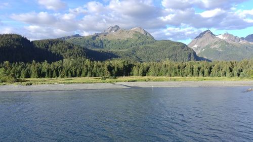 Scenic view of lake by mountains against sky