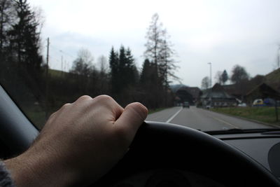 Cropped hand of person driving car