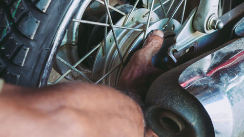 Cropped hand of man repairing motorcycle