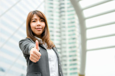 Young businesswoman gesturing while standing in city
