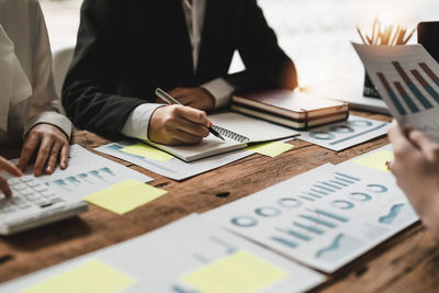 Midsection of business colleagues working on table