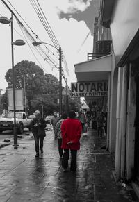 People walking on wet street in city