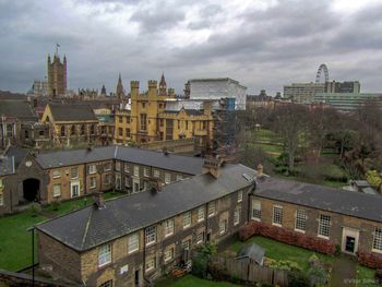 View of cityscape against cloudy sky