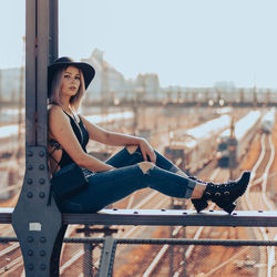 Portrait of smiling woman sitting against sky