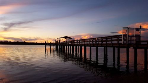 Pier over sea against sky during sunset