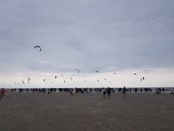 People at beach against sky