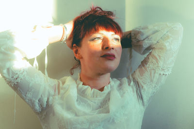 Portrait of young woman sitting on bed at home