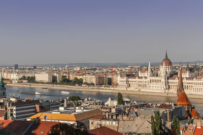 Danube river amidst buildings in city against clear sky