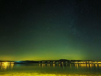 Scenic view of lake against sky at night