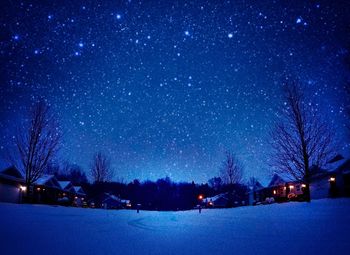 Scenic view of snow field against sky at night
