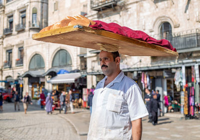 Portrait of man standing on street in city