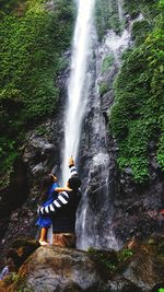 Rear view of waterfall against rocks in water