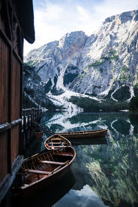 Boats in lake against snowcapped mountains