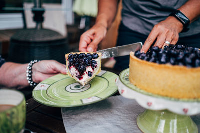 Midsection of woman preparing cake on table