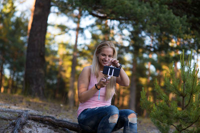 Young woman using mobile phone in forest