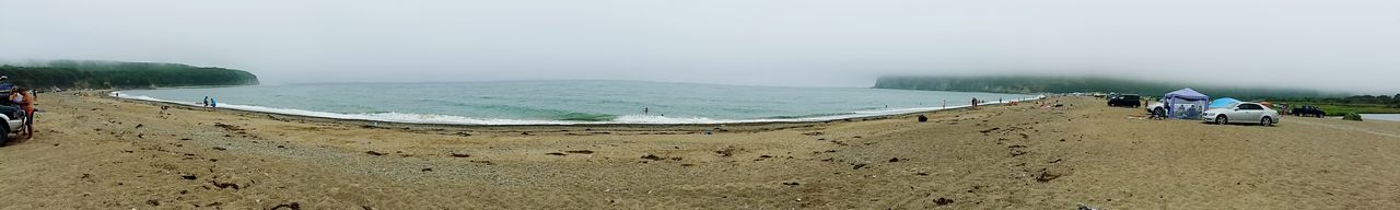 Scenic view of beach against cloudy sky