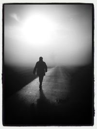 Rear view of woman standing in foggy weather