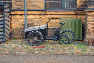 A tricycle cargo bike with box for the  children stands on a street in old town. copenhagen, denmark